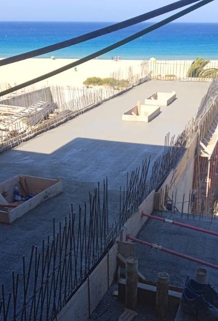 Fachada de un edificio moderno caracterizada por su diseño geométrico de soportes diagonales. Las líneas limpias y estructuradas, combinadas con grandes ventanales, crean una estética contemporánea y minimalista. El cielo despejado acentúa la sofisticación del diseño arquitectónico.